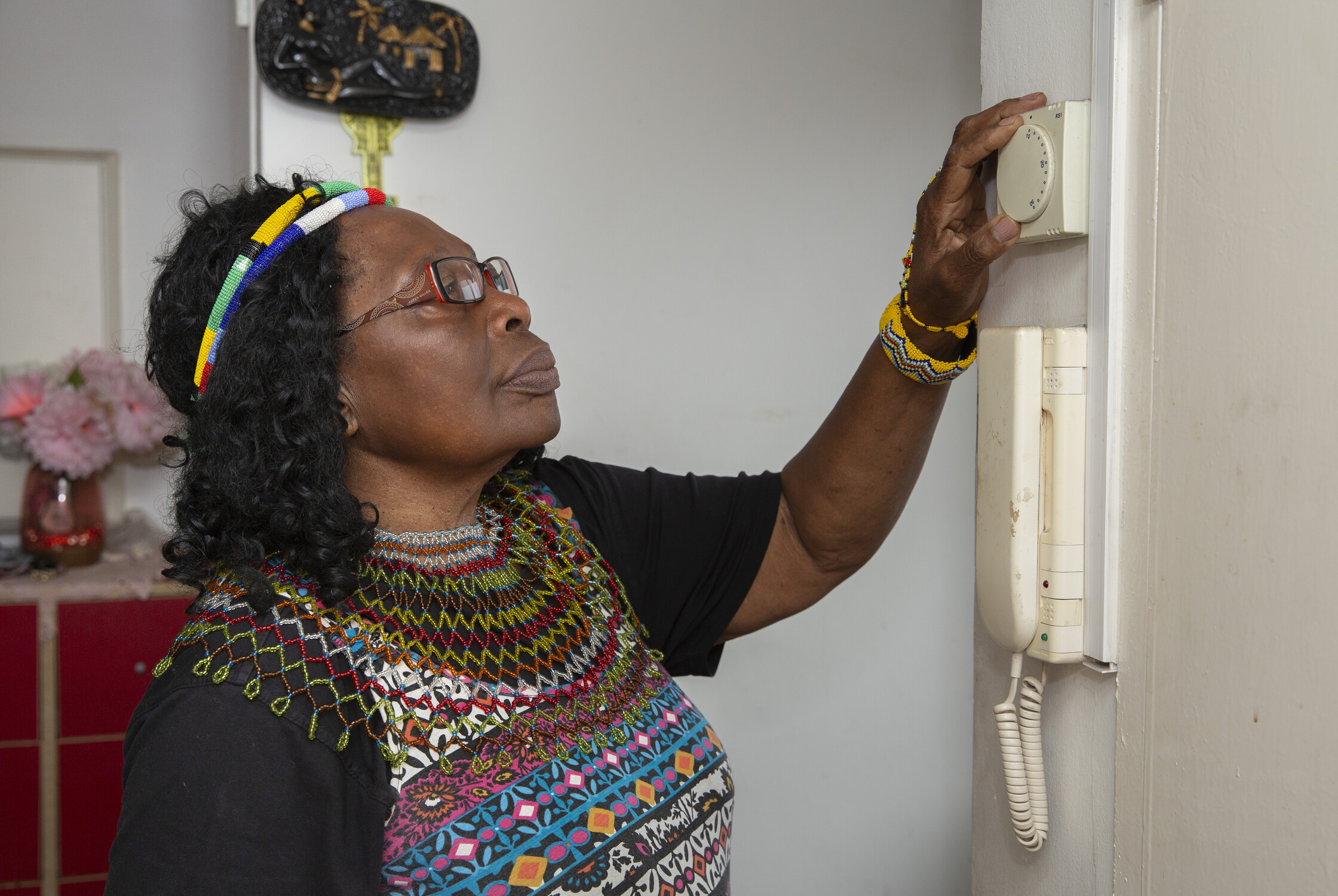 Woman adjusting a thermostat on the wall