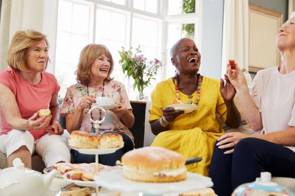 Women laughing together having an afternoon tea