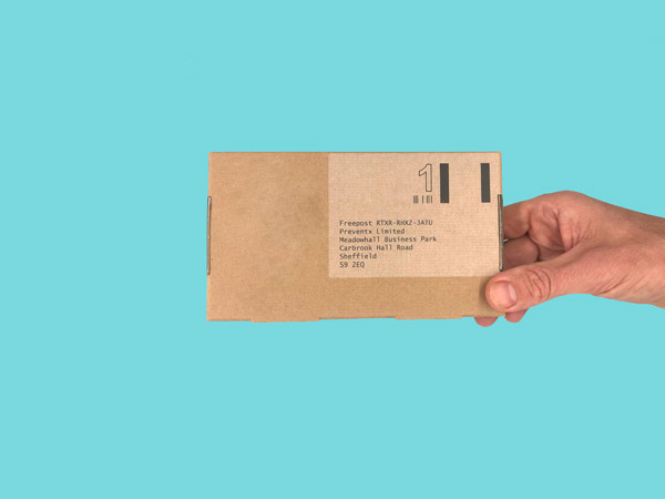 Someone holding a brown cardboard box which is a STI test kit