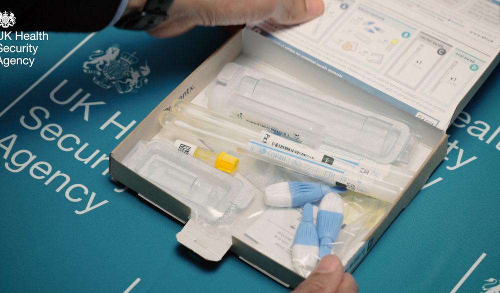 An open STI test kit in a cardboard box